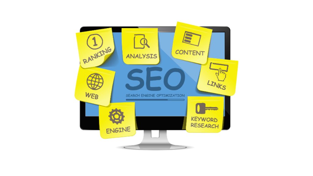 Computer screen with sticky notes showing SEO concepts like keywords, content, analytics, ranking, and backlinks for building an SEO-optimized website.